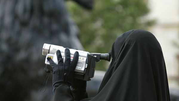 A woman in traditional Muslim gowns videofilms her family under the watchful eyes of the lions guarding the Nelson column at Trafalgar square in London, 12 August 2002. A woman in traditional Muslim gowns videofilms her family under the watchful eyes of the lions guarding the Nelson column at Trafalgar square in London, 12 August 2002. - Sputnik International