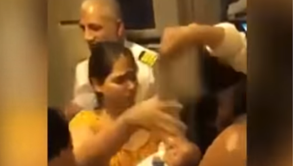 A woman on Pakistani International Airlines Flight 750 pleads with airline staff to open the plane doors for ventilation after her baby passed out from excessive heat, August 3, 2018 - Sputnik International