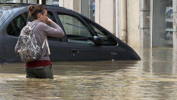 A woman walks on a flooded street caused by heavy rain and thunder storms, in Salies-de-Bearn, southwestern France, Wednesday, June 13, 2018 - Sputnik International
