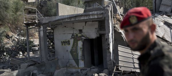 A Palestinian Hamas military policeman inspects the damage caused by Israeli airstrikes in Gaza City, Thursday, Aug. 9, 2018. Israel struck targets in the Gaza Strip after dozens of rockets were launched Wednesday from the coastal territory ruled by the Islamic militant Hamas group, the Israeli military said - Sputnik International