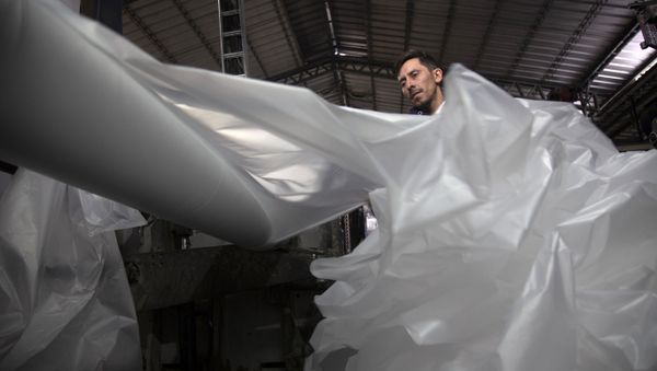 A worker checks the printing of supermarket plastic bags in a factory in Santiago, on July 18, 2018. - Sputnik International