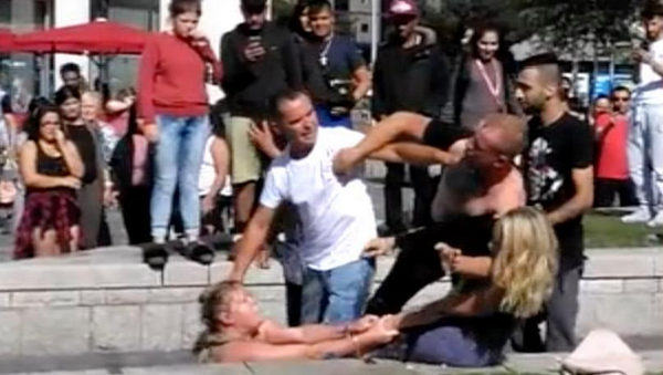 A woman in purple dress is seen throwing liquid in the face of a woman in beige - Sputnik International