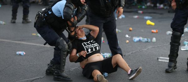 Police stand near protester during a demonstration in Bucharest Police stand near protester during a demonstration in Bucharest - Sputnik International