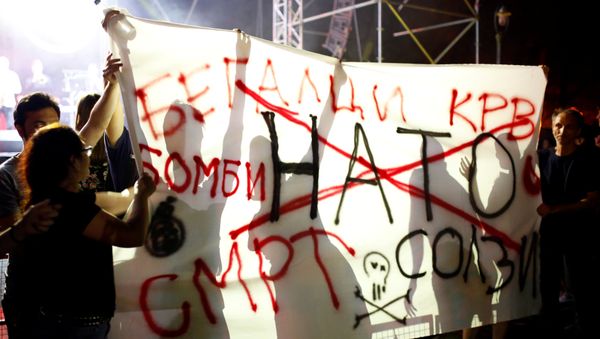 Anti-NATO protestors hold a banner with the message NATO refugees blood bombs death tears during events organized by the government in 15 towns to celebrate an invitation for Macedonia to join NATO, in Skopje, Macedonia July 14, 2018 - Sputnik International