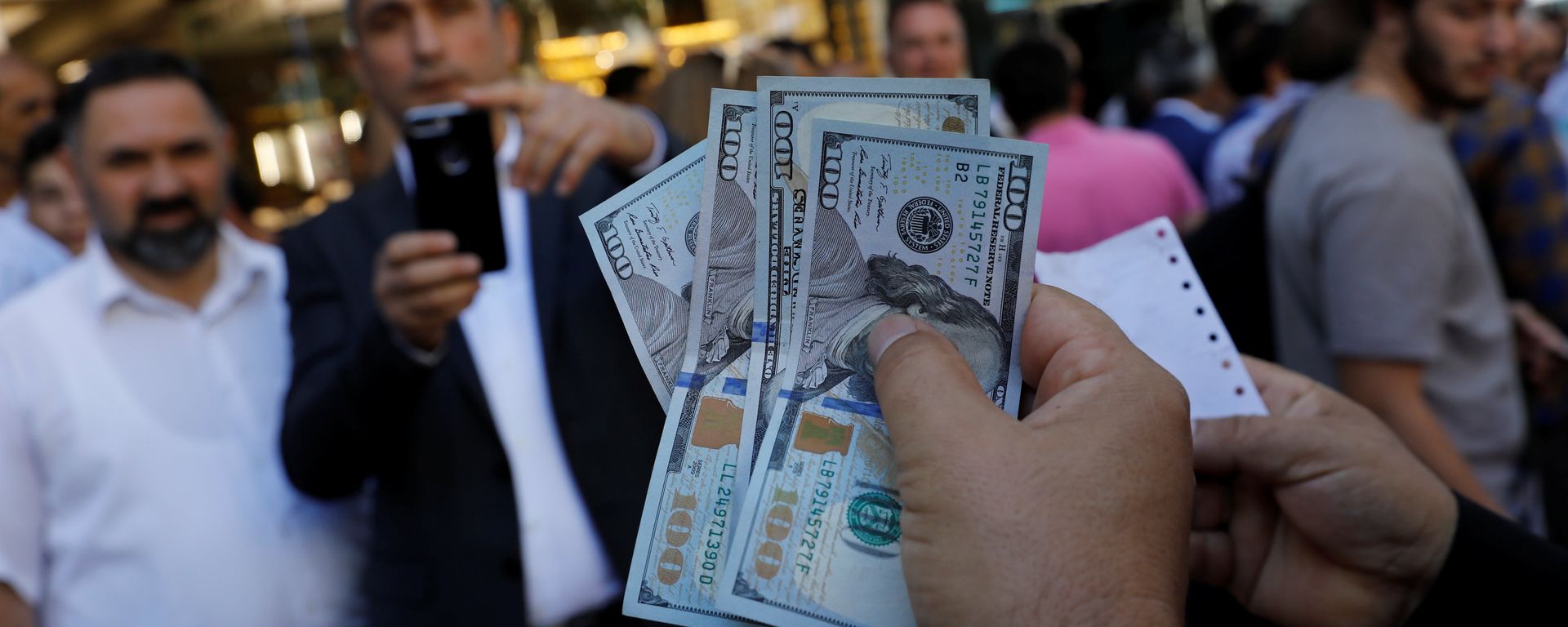 A businessman holding U.S. dollars poses for his friend in front of a currency exchange office in response to the call of Turkish President Tayyip Erdogan on Turks to sell their dollar and euro savings to support the lira, in Ankara, Turkey August 14, 2018 A businessman holding U.S. dollars poses for his friend in front of a currency exchange office in response to the call of Turkish President Tayyip Erdogan on Turks to sell their dollar and euro savings to support the lira, in Ankara, Turkey August 14, 2018 - Sputnik International, 1920, 16.08.2018
