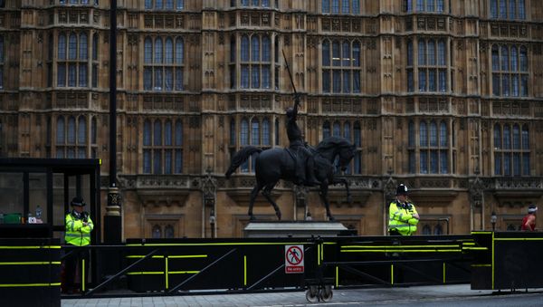 Police officers stand at the vehicle barrier to the Houses of Parliament where a car crashed after knocking down cyclists and pedestrians yesterday in Westminster, London, Britain, August 15, 2018 - Sputnik International
