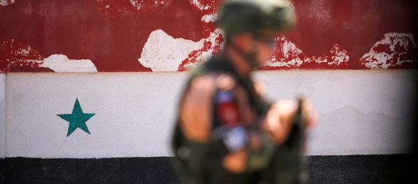 A Russian soldier stands guard near a Syrian national flag A Russian soldier stands guard near a Syrian national flag - Sputnik International