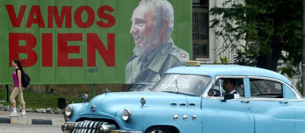 A taxi passes a sign with Cuban President Fidel Castro - Sputnik International