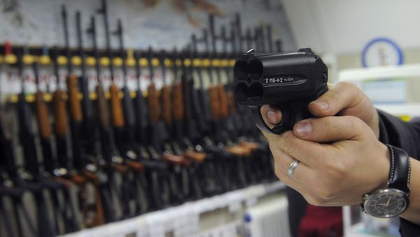A buyer examining Osa traumatic pistol in one of the Moscow arms shops - Sputnik International