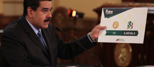 Venezuela's President Nicolas Maduro holds a sign showing the value of a Petro compared with the new Venezuelan currency Bolivar Soberano (Sovereign Bolivar), as he speaks during a meeting with ministers at Miraflores Palace in Caracas, Venezuela August 17, 2018. Venezuela's President Nicolas Maduro holds a sign showing the value of a Petro compared with the new Venezuelan currency Bolivar Soberano (Sovereign Bolivar), as he speaks during a meeting with ministers at Miraflores Palace in Caracas, Venezuela August 17, 2018. - Sputnik International