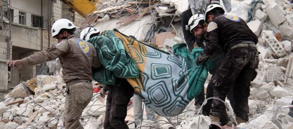 Syrian civil defence volunteers, known as the White Helmets, carry a body retrieved from the rubble following reported government airstrike on the Syrian town of Ariha, in the northwestern province of Idlib, on February 27, 2017 - Sputnik International