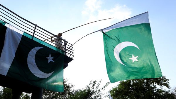 A boy uses a bamboo stick to adjust national flags at an overhead bridge ahead of Pakistan's Independence Day, in Islamabad, Pakistan August 10, 2018 A boy uses a bamboo stick to adjust national flags at an overhead bridge ahead of Pakistan's Independence Day, in Islamabad, Pakistan August 10, 2018 - Sputnik International