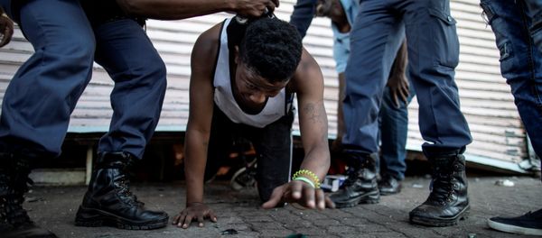 A suspected looter is detained by South African police officers as he emerges from of a looted foreign-owned shop in Soweto, Johannesburg, on August 29, 2018 during unrest that erupted after a foreign shop owner allegedly shot and killed a member of the community during a demonstration - Sputnik International