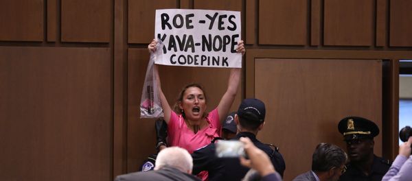 A protester is removed during the start of U.S. Supreme Court nominee judge Brett Kavanaugh's Senate Judiciary Committee confirmation hearing on Capitol Hill in Washington, U.S., September 4, 2018 - Sputnik International
