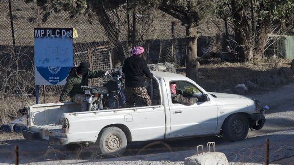 A group of men, not specified which group of rebels, drive into an abandoned UN post at Syria's Quneitra border crossing between Syria and the Israeli-controlled Golan Heights, seen from the Israeli-controlled Golan Heights, Monday, Nov. 28, 2016. - Sputnik International