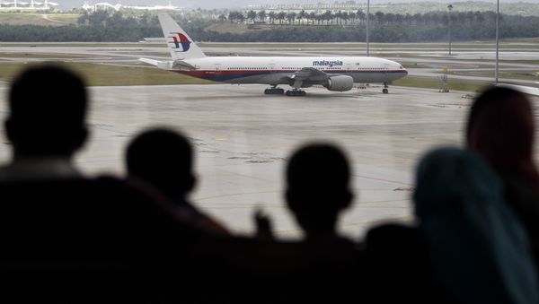 A Malaysian family is silhouetted against a taxied Malaysia Airlines Boeing 777 plane at the Kuala Lumpur International Airport in Sepang, Malaysia, Saturday, March 5, 2016 - Sputnik International