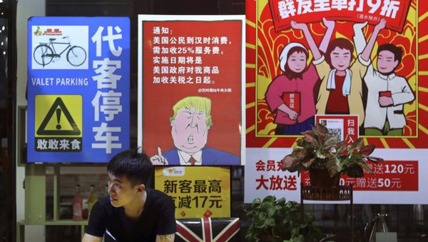In this Monday, Aug. 13, 2018, photo, a man stands near a poster depicting a mural of U.S. President Donald Trump stating that all American costumers will be charged 25 percent more than others starting from the day president Trump started the trade war against China, on display outside a restaurant in Guangzhou in south China's Guangdong province. The recent trade war between the world's two biggest economies has forced many multinational companies to reschedule purchases and rethink where they buy materials and parts to try to dodge or blunt the effects of tit-for-tat tariffs between Washington and Beijing - Sputnik International