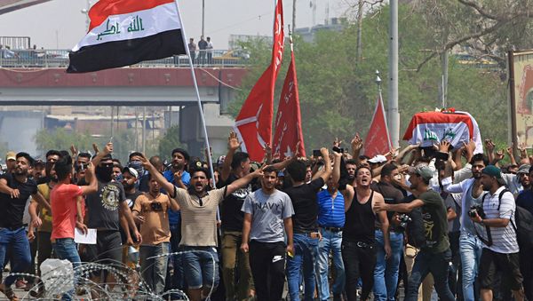 Mourners chant anti government slogans while carrying the Iraqi flag-draped coffin of Mekki Yasser, a protester whose family and activists said he was killed when he participated in a protest last night, during his funeral on Tuesday, Sept. 4, 2018 - Sputnik International