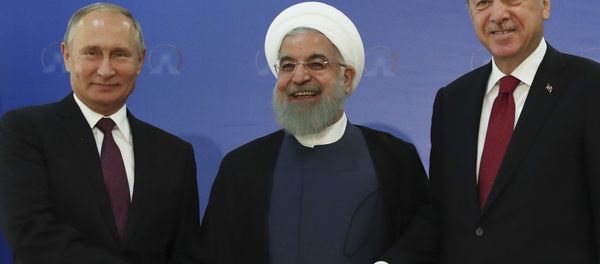 Iran's President Hassan Rouhani, centre, flanked by Russia's President Vladimir Putin, left, and Turkey's President Recep Tayyip Erdogan, pose for photographs in Tehran, Iran, ahead of their summit to discuss Syria, Friday, Sept. 7, 2018 Iran's President Hassan Rouhani, centre, flanked by Russia's President Vladimir Putin, left, and Turkey's President Recep Tayyip Erdogan, pose for photographs in Tehran, Iran, ahead of their summit to discuss Syria, Friday, Sept. 7, 2018 - Sputnik International