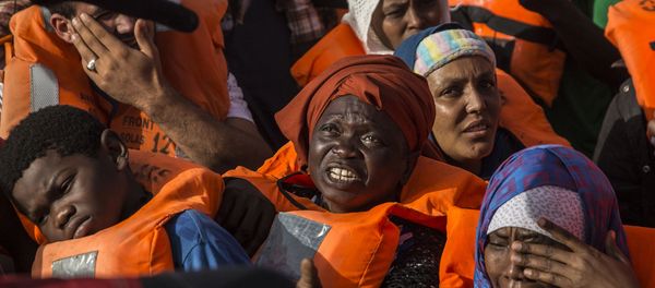 Migrants aboard a rubber dinghy off the Libyan coast receive aid from rescuers aboard the Open Arms aid boat, of Proactiva Open Arms Spanish NGO, Saturday, June 30, 2018. - Sputnik International