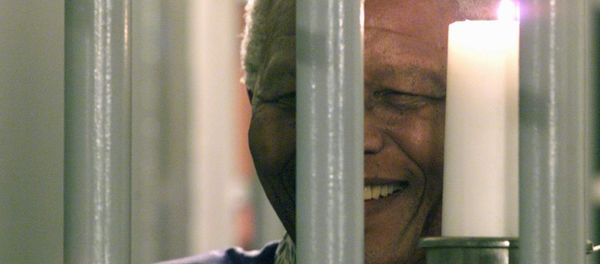 Former South African President Nelson Mandela holds a symbolic millennium candle 31 December 1999 in his cell at the prison of Robben Island where he was imprisoned for 27 years during the apartheid time. Former South African President Nelson Mandela holds a symbolic millennium candle 31 December 1999 in his cell at the prison of Robben Island where he was imprisoned for 27 years during the apartheid time. - Sputnik International