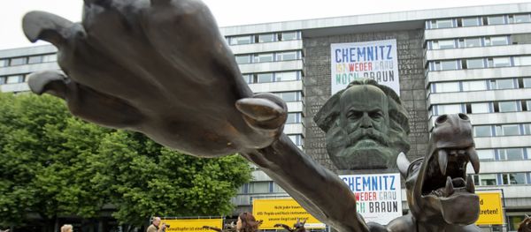 People walk between sculptures by artist Rainer Opolka in front of the Karl Marx Monument in Chemnitz, eastern Germany, Thursday, Sept. 13, 2018. The figure in the foreground is one of 10 life-sized metal wolf sculptures as a part of the spontan exhibition 'Wolves with Hitler salute howl in front of the Karl-Marx-Monument', to protest against xenophobia and right-wing extremism. - Sputnik International