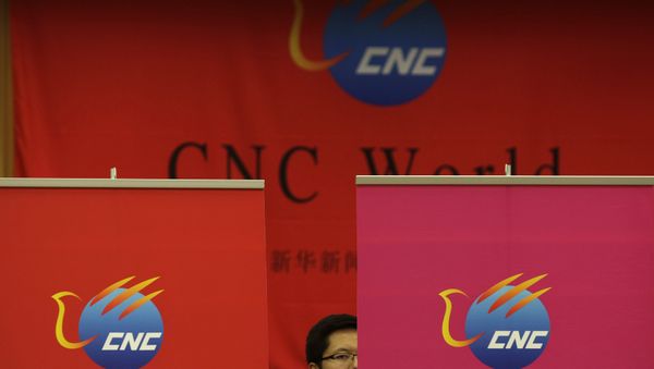 A Chinese employee of China Xinhua News Network Corp. (CNC) looks on during a media conference on the launching of its global, English-language television channel in Beijing Thursday, July 1, 2010. - Sputnik International
