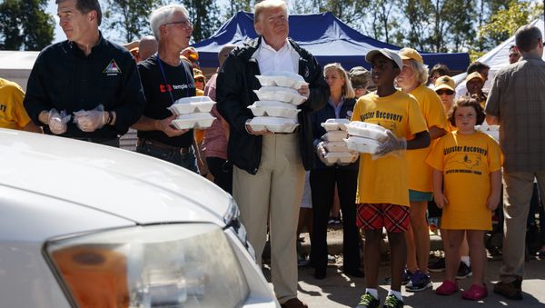 President Donald Trump hands out prepackaged meals to people in cars at Temple Baptist Church in an area impacted by Hurricane Florence. - Sputnik International