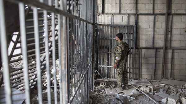 A member of the U.S.-backed Syrian Democratic Forces (SDF) walks inside a prison built by Islamic State fighters at the stadium that was the site of Islamic State fighters' last stand in the city of Raqqa, Syria, Friday, Oct. 20, 2017 - Sputnik International