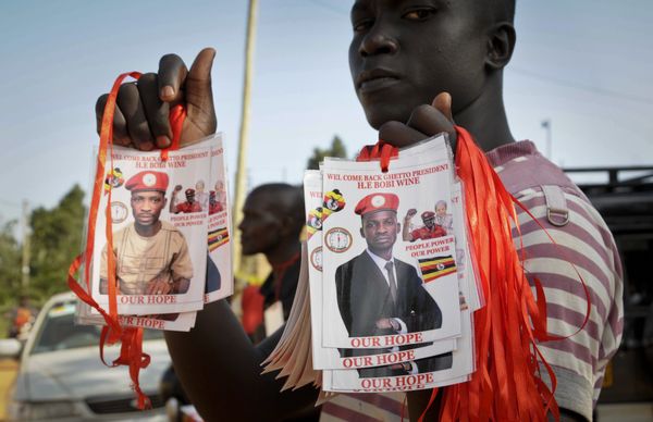 A supporter holds up images of Bobi Wine, a popular Ugandan singer who is now a rising opposition politician - Sputnik International