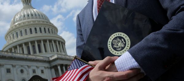 A congressional aide holds flags to give to participants at rally at the U.S. Capitol in Washington, U.S. May 21, 2018 - Sputnik International