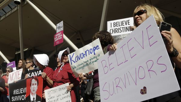 Protestors hold signs during a demonstration against the nomination of Brett Kavanaugh to sit on the U.S. Supreme Court in Portland, Ore., Friday, Sept. 28, 2018 - Sputnik International