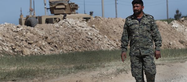 In this April 4, 2018 file photo, a U.S-backed Syrian Manbij Military Council soldier passes a U.S. position near the tense front line with Turkish-backed fighters, in Manbij, north Syria - Sputnik International