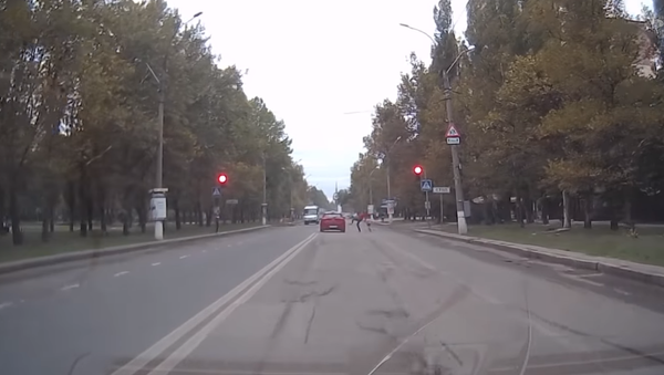 Ukrainian Man Kicks Speeding Car, Knocks Son and Self to Ground - Sputnik International