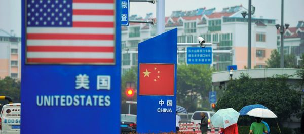 Signs with the US flag and Chinese flag are seen outside a store selling foreign goods in Qingdao in China's eastern Shandong province on September 19, 2018 - Sputnik International