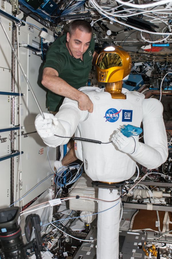 NASA astronaut Chris Cassidy, Expedition 36 flight engineer, works with Robonaut 2, the first humanoid robot in space, during a round of ground-commanded tests in the Destiny laboratory of the International Space Station.  - Sputnik International