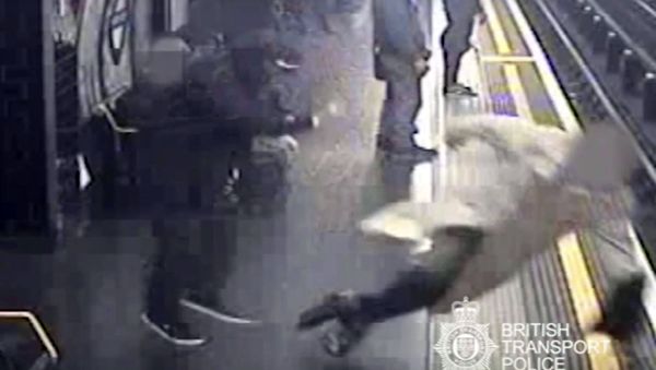 This handout grab taken from CCTV issued by British Transport Police shows Robert Malpas being pushed onto the tracks of Marble Arch Underground station in London - Sputnik International