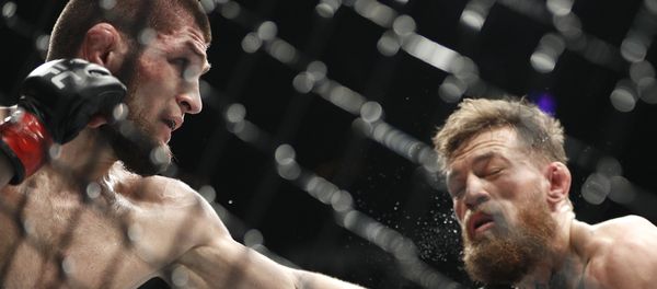Khabib Nurmagomedov, left, punches Conor McGregor during a lightweight title mixed martial arts bout at UFC 229 in Las Vegas, Saturday, Oct. 6, 2018. - Sputnik International