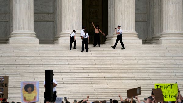 A topless woman is detained by Supreme Court Police after the Senate confirmed the nomination of Judge Brett Kavanaugh in Washington, U.S., October 6, 2018 - Sputnik International