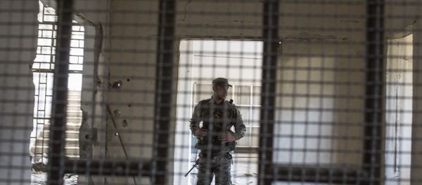A member of the U.S.-backed Syrian Democratic Forces (SDF) walk inside a prison built by Islamic State fighters at the stadium that was the site of IS fighters' last stand in the city of Raqqa, Syria, Friday, Oct. 20, 2017 - Sputnik International