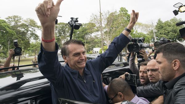 Presidential frontrunner Jair Bolsonaro, of the Social Liberal Party, flashes thumbs up to supporters after voting at a polling station in Rio de Janeiro, Brazil, Sunday, Oct. 7, 2018. Presidential frontrunner Jair Bolsonaro, of the Social Liberal Party, flashes thumbs up to supporters after voting at a polling station in Rio de Janeiro, Brazil, Sunday, Oct. 7, 2018. - Sputnik International