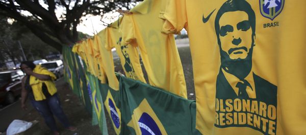A woman sells t-shirts and flags with the image of presidential frontrunner Jair Bolsonaro in front of the headquarters of the national congress in Brasilia A woman sells t-shirts and flags with the image of presidential frontrunner Jair Bolsonaro in front of the headquarters of the national congress in Brasilia - Sputnik International