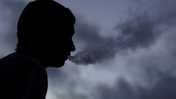 A young man smokes a Suorin Drop electronic cigarette in this picture illustration taken September 14, 2018 - Sputnik International