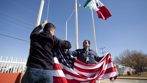 In this Friday, Dec. 27, 2013 photo, workers at one of maquiladoras of the TECMA group prepare to raise the U.S. flag along with the Mexican and TECMA flags in Ciudad Juarez, Mexico - Sputnik International