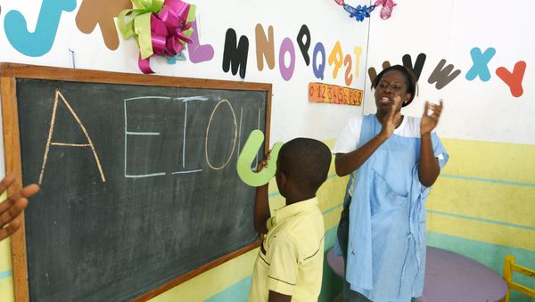 A teacher applauds an autistic child in classroom in Abidjan, Ivory Coast. Autism is less likely to be diagnosed in the developing world - Sputnik International