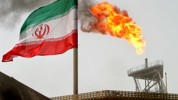 Gas flare on an oil production platform in the Soroush oil fields is seen alongside an Iranian flag in the Gulf July 25, 2005 Gas flare on an oil production platform in the Soroush oil fields is seen alongside an Iranian flag in the Gulf July 25, 2005 - Sputnik International