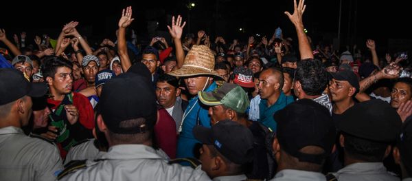 Honduran migrants taking part in a new caravan heading to the US, talk with Guatemalan police officers on their arrival to Chiquimula, Guatemala, on October 22, 2018 - Sputnik International