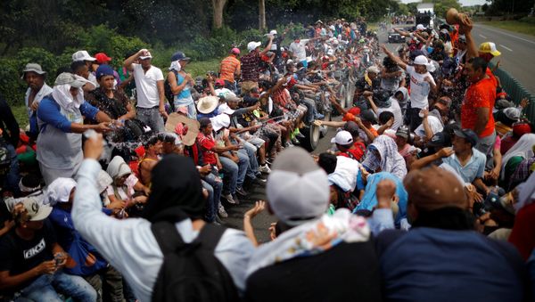 Central American migrants, who are part of a caravan of migrants trying to reach the United States, hitchhike on a truck along the highway as they continue their journey in Tapachula, Mexico October 22, 2018 Central American migrants, who are part of a caravan of migrants trying to reach the United States, hitchhike on a truck along the highway as they continue their journey in Tapachula, Mexico October 22, 2018 - Sputnik International