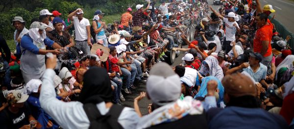 Central American migrants, who are part of a caravan of migrants trying to reach the United States, hitchhike on a truck along the highway as they continue their journey in Tapachula, Mexico October 22, 2018 Central American migrants, who are part of a caravan of migrants trying to reach the United States, hitchhike on a truck along the highway as they continue their journey in Tapachula, Mexico October 22, 2018 - Sputnik International