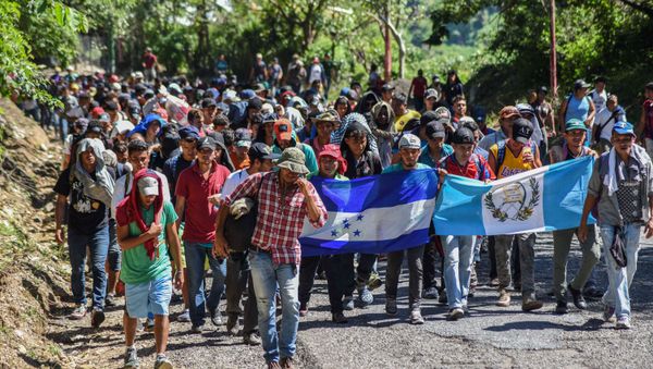 Honduran migrants take part in a new caravan heading to the US with Honduran and Guatemalan national flags in Quezaltepeque, Chiquimula, Guatemala on October 22, 2018 Honduran migrants take part in a new caravan heading to the US with Honduran and Guatemalan national flags in Quezaltepeque, Chiquimula, Guatemala on October 22, 2018 - Sputnik International